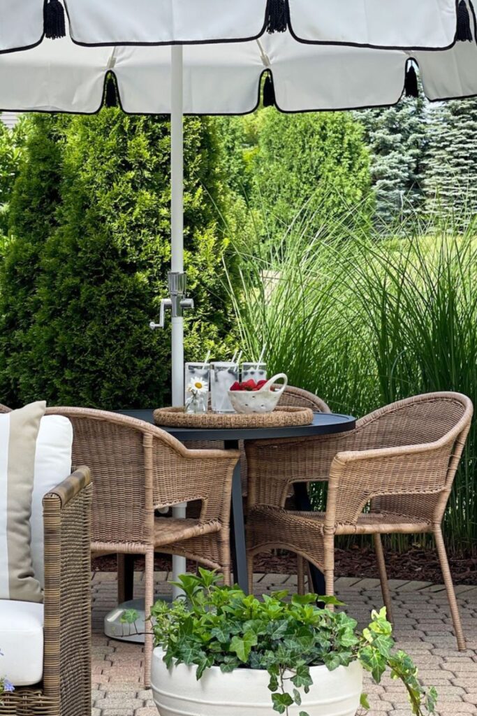 a table and chairs outside with a white umbrella