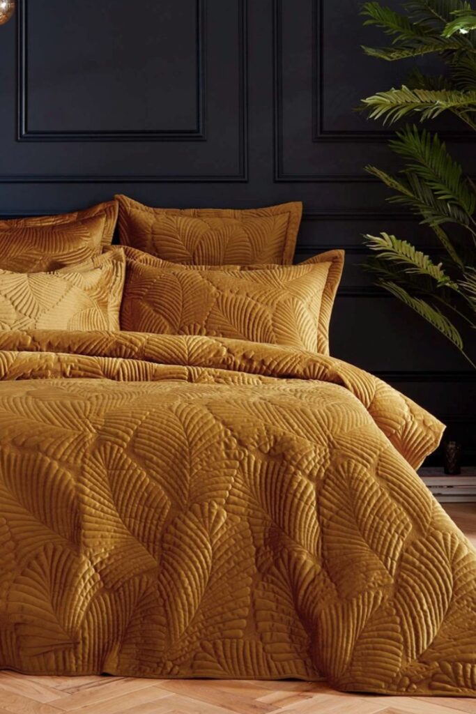 Mix Gold Bedding With Black Wall